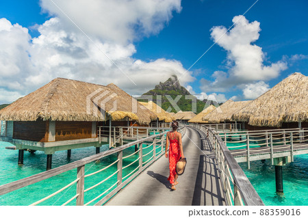 Tahiti luxury hotel honeymoon travel vacation tourist woman walking at luxury resort in overwater bungalows villas. View of Mount Otemanu, Bora Bora, French Polynesia 88359016