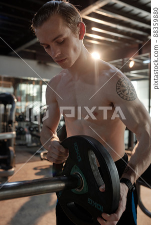 Sportsman Putting More Weight on Barbbell Sportsman Putting More Weight on Barbbell 88359880