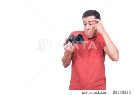 Puzzled man looking at photo camera with confuse 88360820