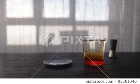 tonic water with orange syrup in tumbler glass on wood table 88361340