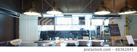 Open area kitchen for breakfast. Dishes and food samples were placed on the counter. Food list on black board 88362845