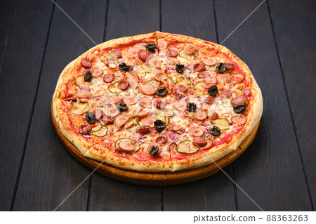 Pizza with various kind of thin sausages, pickled cucumber, olives and onion Pizza with various kind of thin sausages, pickled cucumber, olives and onion 88363263