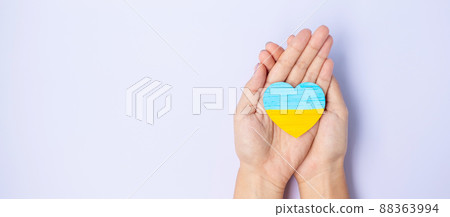 Support for Ukraine in the war with Russia, Hands holding symbol of Heart with flag of Ukraine. Pray, No war, stop war and  stand with Ukraine 88363994