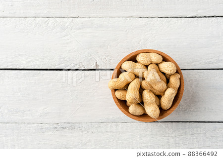 Overhead shot of peanuts in bowl on white wooden table. Healthy snacks Overhead shot of peanuts in bowl on white wooden table. Healthy snacks 88366492