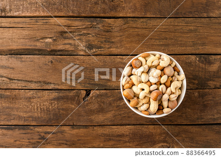 Various kinds of nuts (almonds, pistachios, peanuts, hazelnuts and cashews) in bowl on wooden table. Close up Various kinds of nuts (almonds, pistachios, peanuts, hazelnuts and cashews) in bowl on wooden table. Close up 88366495