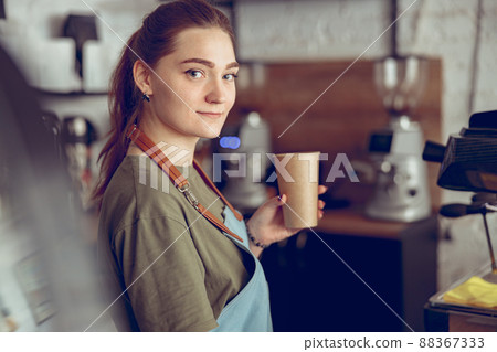 Female barista with cup of coffee working in cafe Female barista with cup of coffee working in cafe 88367333
