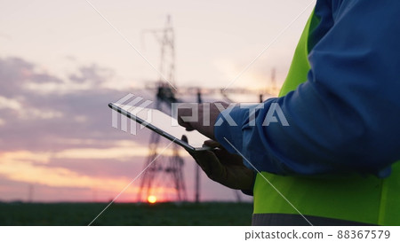 technology concept with high voltage power lines. electrical engineer helmet digital tablet sunset. power engineer power plant high voltage voltage energy. concept electrical engineer working sunset 88367579