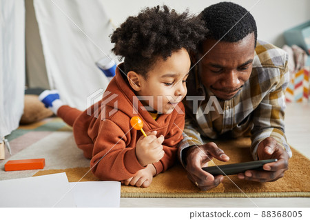 Father and Son Watching Cartoons at Smartphone 88368005