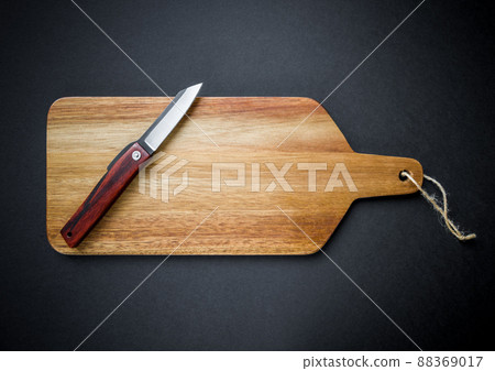 Traditional japanese pocket knife on a wooden cutting board Traditional japanese pocket knife on a wooden cutting board 88369017