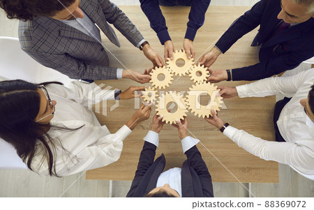 People stacking wooden gears next to each other, symbolizing development and success. People stacking wooden gears next to each other, symbolizing development and success. 88369072
