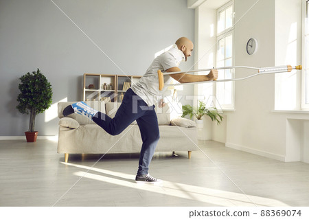 Happy man with broken neck and other injuries having fun while recovering at home Happy man with broken neck and other injuries having fun while recovering at home 88369074