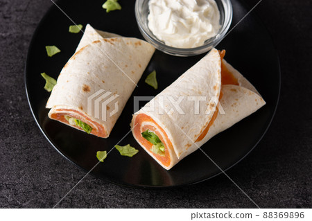 Salmon wrap sandwich roll with cheese and vegetables Salmon wrap sandwich roll with cheese and vegetables 88369896