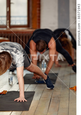 group of athletic young people in sportswear doing push ups or plank at the gym, group fitness concept group of athletic young people in sportswear doing push ups or plank at the gym, group fitness concept 88371943