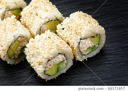 Traditional delicious fresh sushi roll set on a black background. Sushi roll with rice, cream cheese, avocado, salmon, sesame. Philadelphia. Sushi menu. Japanese kitchen, restaurant. Traditional delicious fresh sushi roll set on a black background. Sushi roll with rice, cream cheese, avocado, salmon, sesame. Philadelphia. Sushi menu. Japanese kitchen, restaurant. 88371957