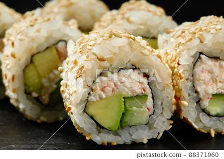 Traditional delicious fresh sushi roll set on a black background. Sushi roll with rice, cream cheese, avocado, salmon, sesame. Philadelphia. Sushi menu. Japanese kitchen, restaurant. Traditional delicious fresh sushi roll set on a black background. Sushi roll with rice, cream cheese, avocado, salmon, sesame. Philadelphia. Sushi menu. Japanese kitchen, restaurant. 88371960