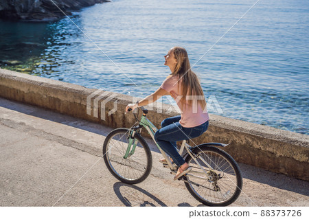 Woman tourist on a bicycle explores Budva in Montenegro. Cycling in Montenegro concept 88373726