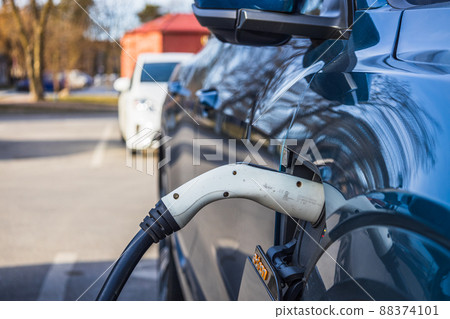 Electric vehicle or EV car with the power cable supply plugged in Electric vehicle or EV car with the power cable supply plugged in 88374101