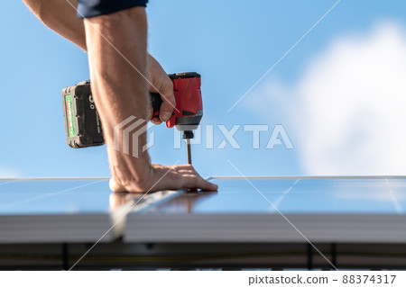 Unidentified man attaching solar panel to the roof rack 88374317