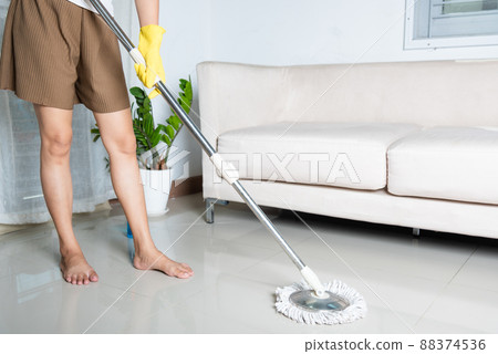 Asian woman washes the floor with a mop and rag indoors 88374536