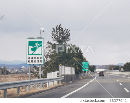 Highway tsunami warning evacuees caution tsunami evacuation site sign Highway tsunami warning evacuees caution tsunami evacuation site sign 88377641