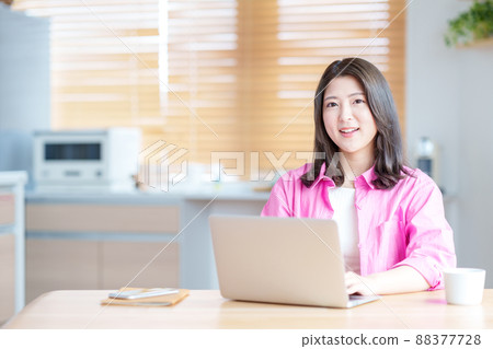 A young woman teleworking in the living room A young woman teleworking in the living room 88377728