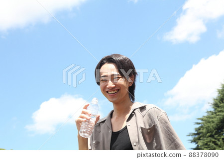 A smiling young man drinking mineral water A smiling young man drinking mineral water 88378090