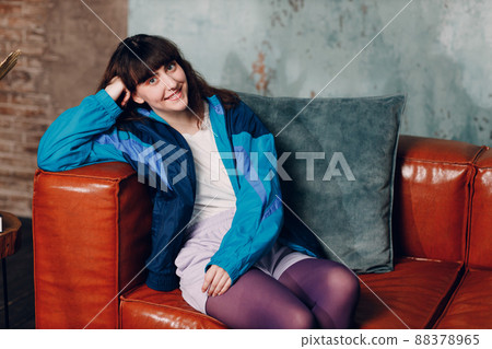 Young sporty woman 80 and 90's style. 90s fashion positive girl sitting home apartment 88378965