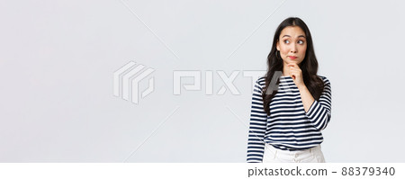 Lifestyle, beauty and fashion, people emotions concept. Thoughtful young asian girl searching for solution, thinking looking away and touching chin while pondering decision Lifestyle, beauty and fashion, people emotions concept. Thoughtful young asian girl searching for solution, thinking looking away and touching chin while pondering decision 88379340