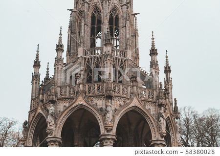 The monument of the King Leopold I in Laeken park in Brussels.  Facade of old church under blue sky. Low angle of ancient cathedral with dome and arched arches in sunny day 88380028