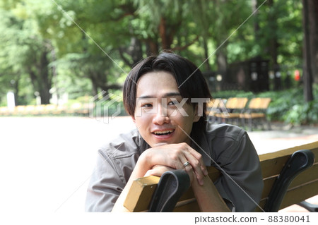 A smiling young man relaxing in the park A smiling young man relaxing in the park 88380041