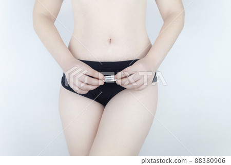 Vaginal or rectal candle in the hands of a woman against the background of the abdomen and underwear. Treatment vaginal infections, candidiasis, thrush and sexually transmitted infections 88380906