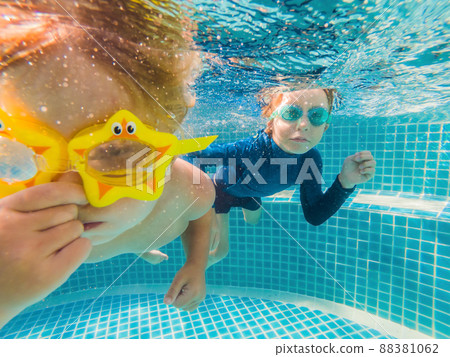 Kids having fun playing underwater in swimming pool on summer vacation Kids having fun playing underwater in swimming pool on summer vacation 88381062