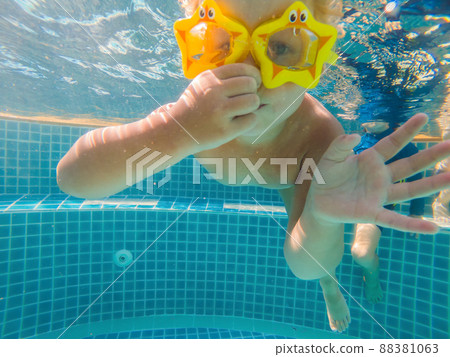 little girl deftly swim underwater in pool little girl deftly swim underwater in pool 88381063