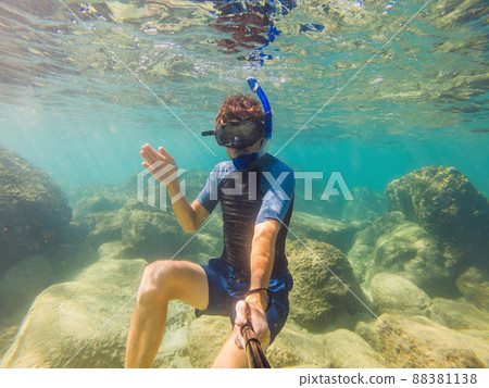 young men snorkeling exploring underwater coral reef landscape background in the deep blue ocean with colorful fish and marine life young men snorkeling exploring underwater coral reef landscape background in the deep blue ocean with colorful fish and marine life 88381138