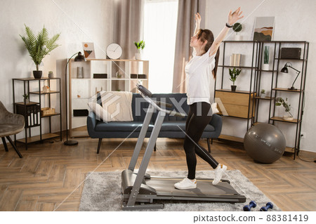 Woman running on treadmill and doing breathing exercises. Woman running on treadmill and doing breathing exercises. 88381419