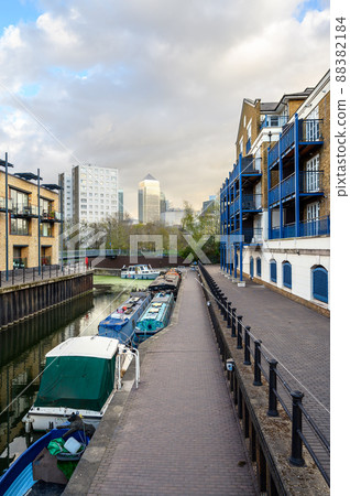 Limehouse, London, UK: Boats moored on a canal near Limehouse Basin, a marina in the docklands area of eastern London. Apartments to the side and Canary Wharf behind. 88382184