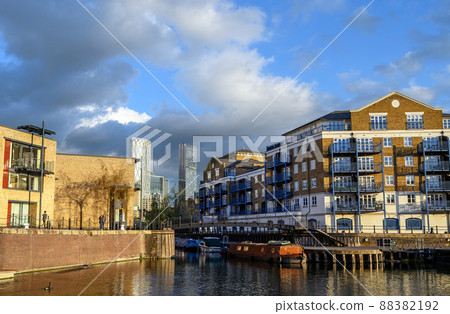 Limehouse, London, UK: View of the Limehouse Basin, a marina in the docklands area of east London. Tall buildings of Canary Wharf are behind. Boats are moored by the side of the dock. Limehouse, London, UK: View of the Limehouse Basin, a marina in the docklands area of east London. Tall buildings of Canary Wharf are behind. Boats are moored by the side of the dock. 88382192