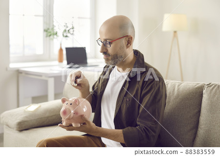 Provident man put coin in piggybank Provident man put coin in piggybank 88383559