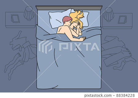 Happy couple cuddle in bed after sex 88384228