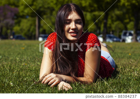 pretty young woman in red dress smiling cheerful in green park on summer sunny day, lifestyle people concept pretty young woman in red dress smiling cheerful in green park on summer sunny day, lifestyle people concept 88384237