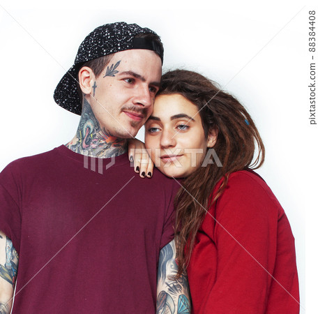 Young couple together. guy with tattoo, girlfriend wearing dreadlocks having fun on white background Young couple together. guy with tattoo, girlfriend wearing dreadlocks having fun on white background 88384408