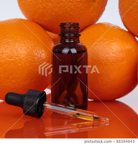 Orange essential oil in a small bottle Selective focus. 88384843