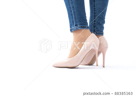 Slender female legs in patent leather shoes with high heels. Dark blue jeans. Fashion and Style. Side view Slender female legs in patent leather shoes with high heels. Dark blue jeans. Fashion and Style. Side view 88385163