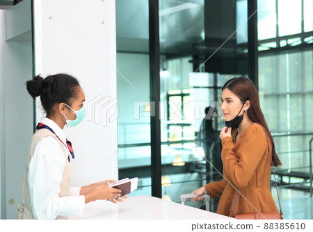 Airport security check at gates to people going on trip to terminal entrance while wearing sterile masks Airport security check at gates to people going on trip to terminal entrance while wearing sterile masks 88385610
