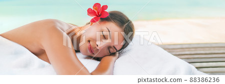 Massage spa and Body care outside on beach at luxury vacation resort. Asian beauty woman relaxing sleeping lying on table during aromatherapy treatment with coconut oil Massage spa and Body care outside on beach at luxury vacation resort. Asian beauty woman relaxing sleeping lying on table during aromatherapy treatment with coconut oil 88386236