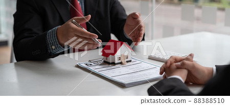 Real estate concept - businessman offer to signs contract with home architectural model at his office 88388510