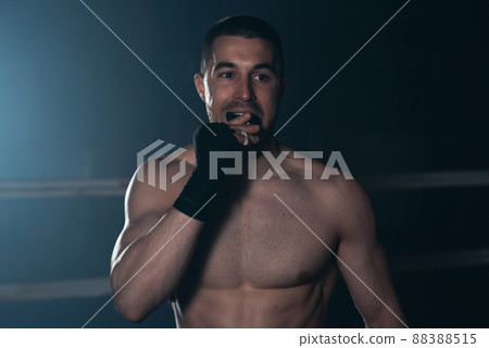Boxer puts Teeth mouth protection in combat sport. Boxer uses mouth guard before fight. Boxer puts Teeth mouth protection in combat sport. Boxer uses mouth guard before fight. 88388515