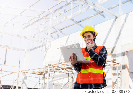 Asian engineer architect worker woman working at build construction site use laptop and talking with radio 88388520