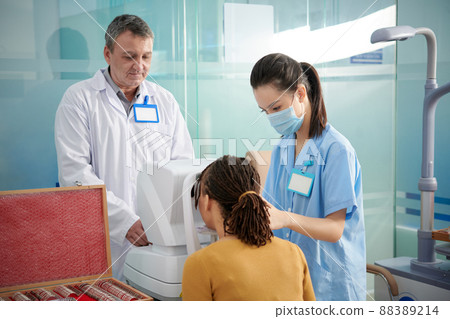 Medical Team Using Autorefractor 88389214