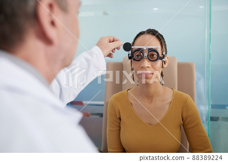 Ophthalmologist Helping Female Patient 88389224